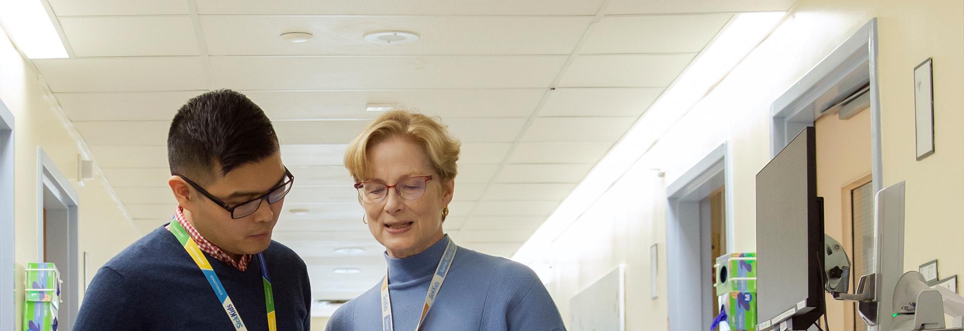 Two pharmacists talking in hospital hallway Two pharmacists talking in hospital hallway