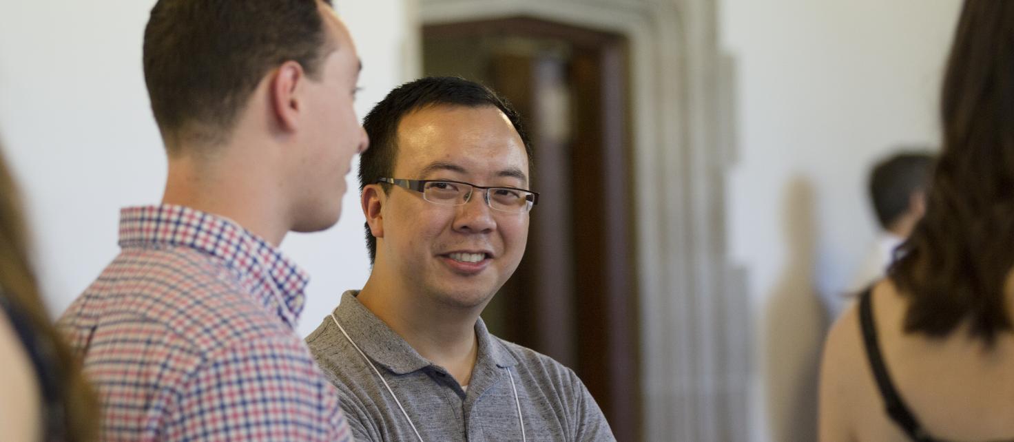 Graduate student conversing with colleagues