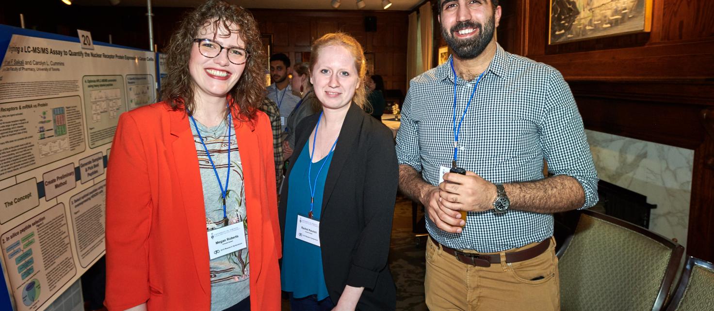 Image of symposium attendees standing near poster presentations