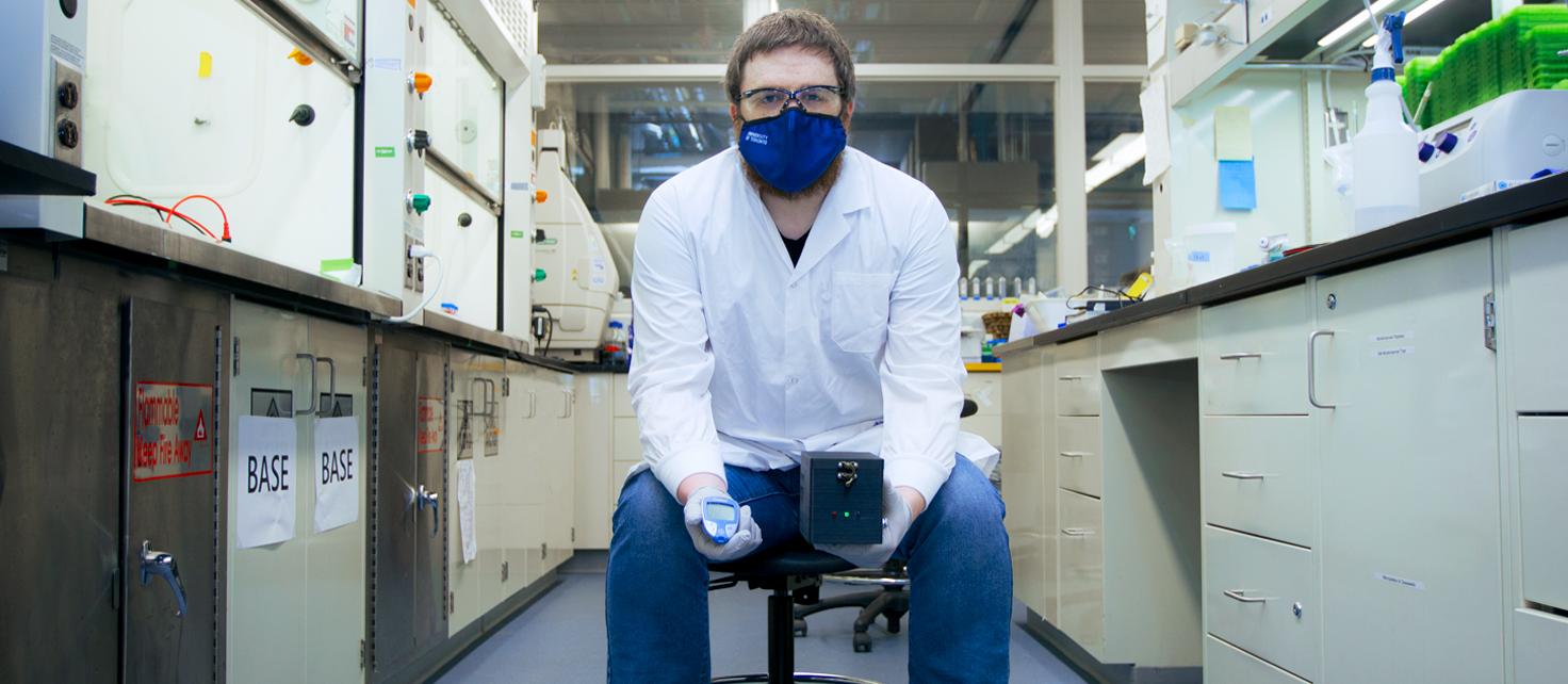 Evan Amalfitano with his glucose meter interface for point-of-care gene circuit-based diagnostics