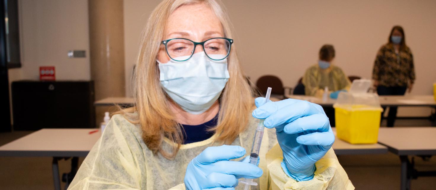 Volunteer holding needle during vaccine clinic training