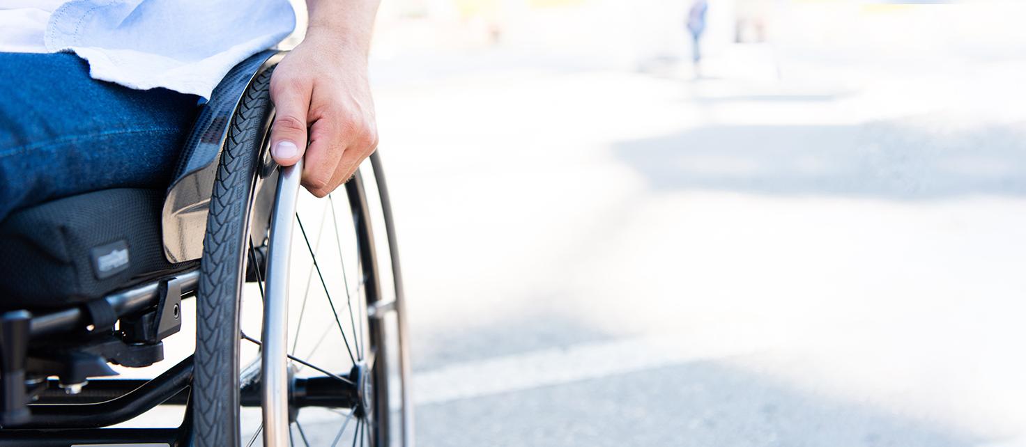 Image of hand holding wheelchair wheel