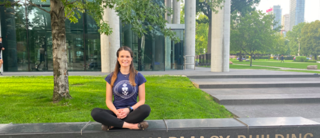 PhD Jasmine Carter sits outside Pharmacy building on U of T campus