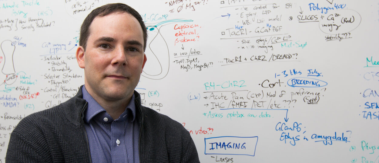 Assistant Professor Rob Bonin in front of his whiteboard
