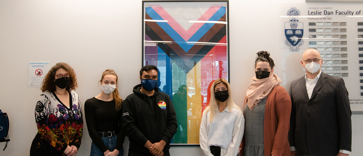 Members of PharmaPride student group alongside Dean Lisa Dolovich Tara O'Leary and Adam Trent in front of inclusion pride flag