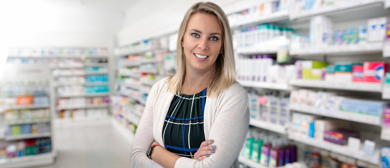 Portrait of Kristen Watt standing in a pharmacy