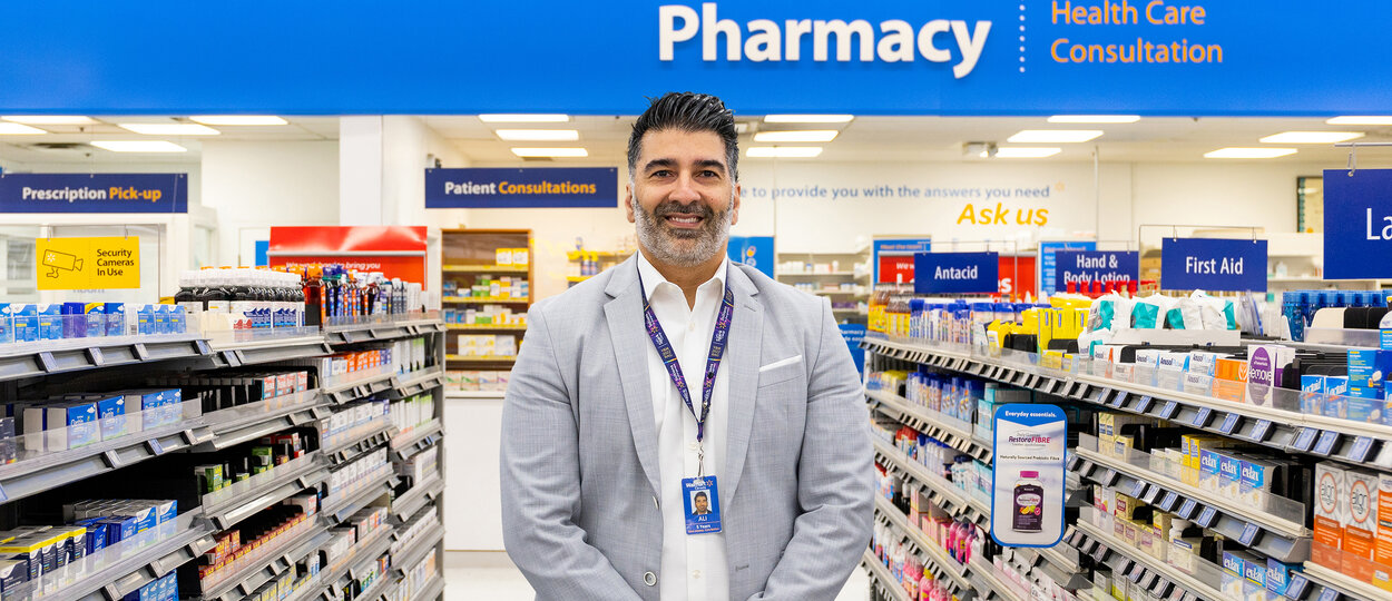 Photo of Ali Ahmadian standing in a Walmart Pharmacy