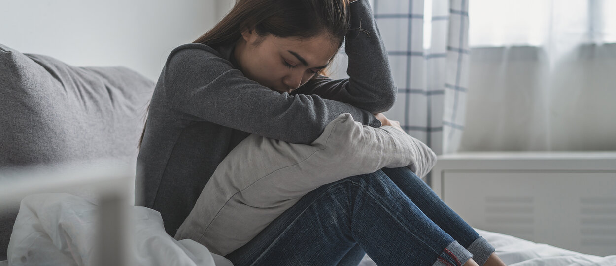 Young women sitting in bed in pain