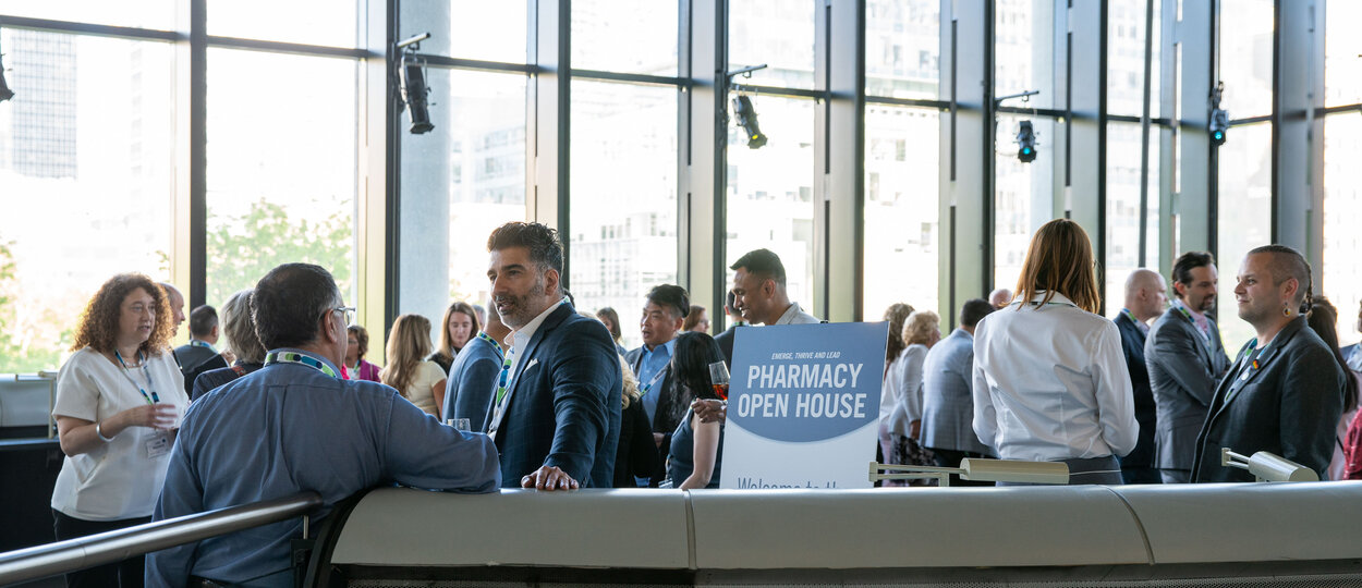 A group of guests in conversation standing on top of third floor lecture pod at the Leslie Dan Faculty of Pharmacy