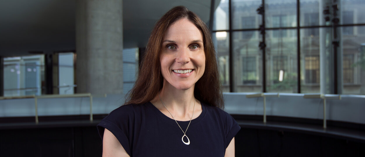 Portrait of Dr. Sara Guilcher with interior of pharmacy building in the background