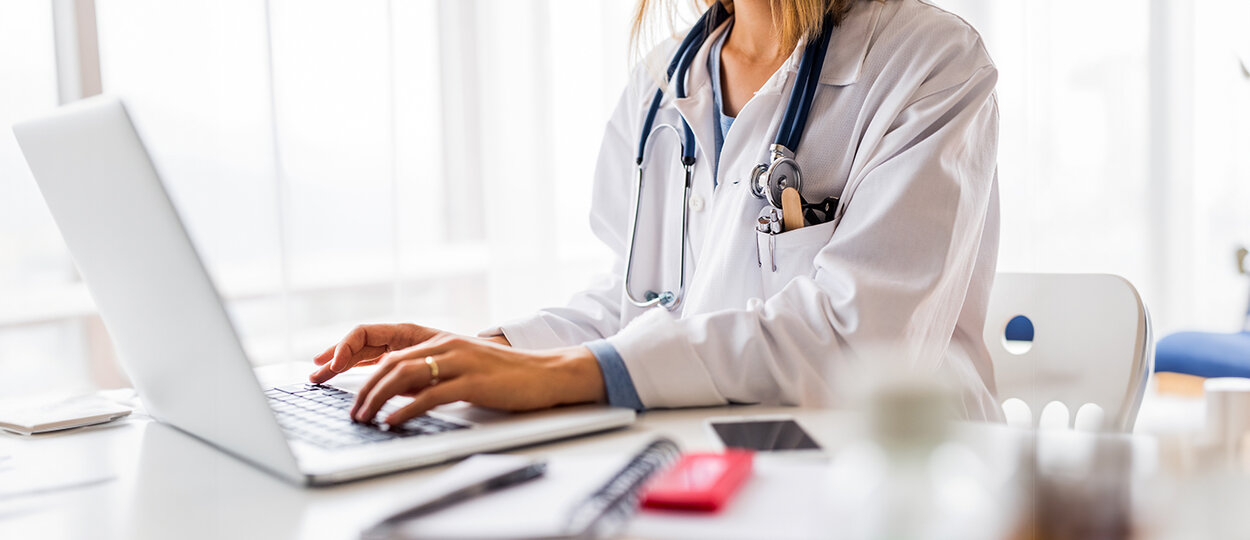 Female doctor with laptop working at the office desk