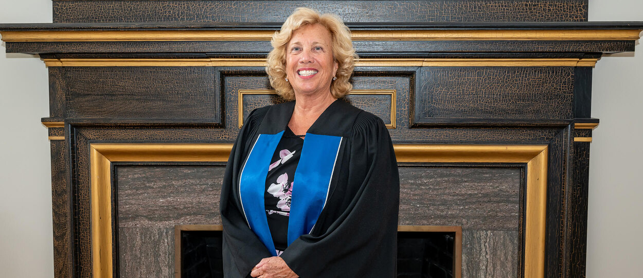 Convocation speaker and U of T Pharmacy alumna Doris Kalamut wearing a black convocation gown with royal blue stole.