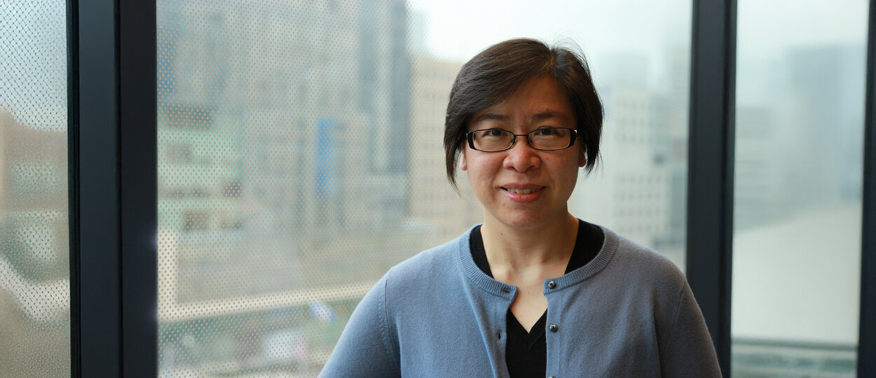 Assistant Professor Certina Ho standing in front of exterior window at Leslie Dan Faculty of Pharmacy
