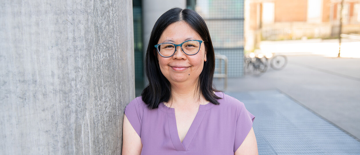 Portrait of Minh-Hien le next to concrete pillar with architectural background