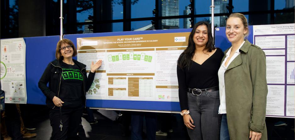 Dr. Anna Taddio with graduate students presenting CARD poster
