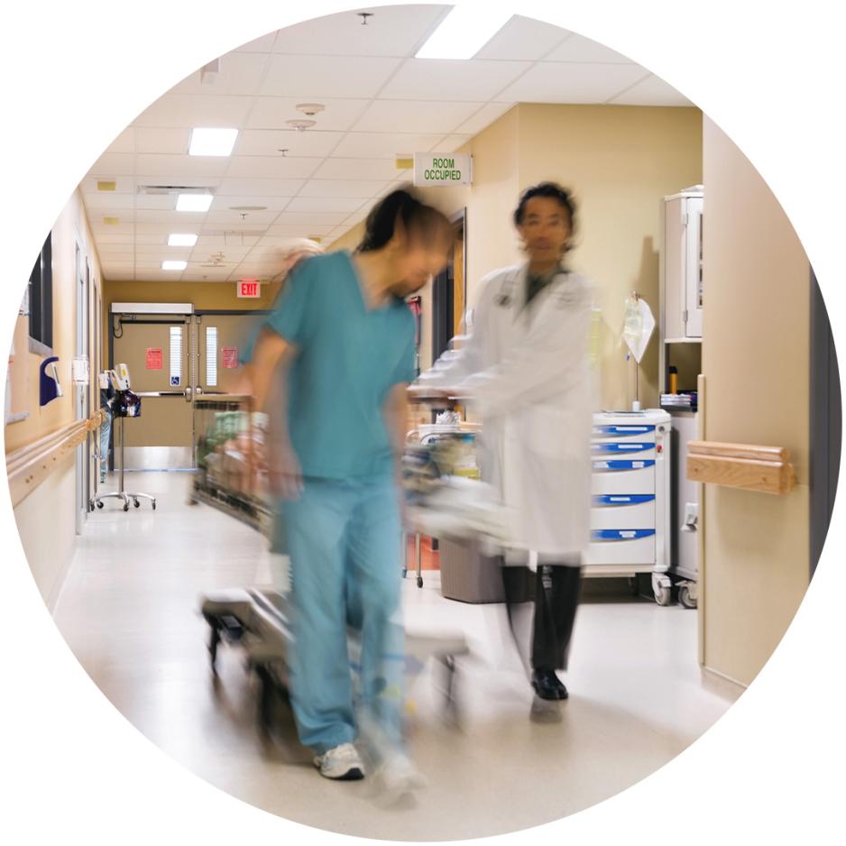Doctor and nurse pushing hospital gurney in hallway