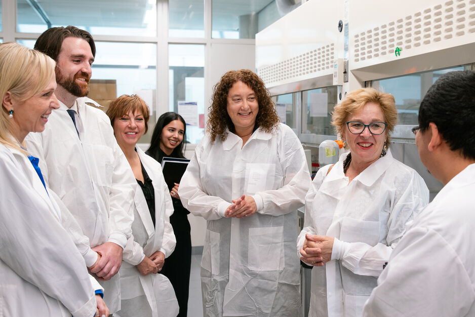 Dean Lisa Dolovich (center) and MPP Martin (second from right) join scientists at U of T's Leslie Dan Faculty of Pharmacy to learn about a new self-driving lab led by Professor Christine Allen (left) to test different combinations of materials and develop optimal drug formulations.