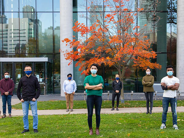 U of T Pharmacy and Engineering Researchers in front of Pharmacy building, physically distanced and wearing masks