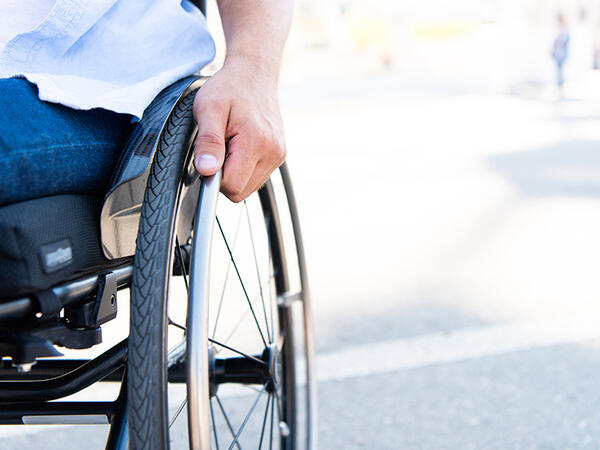 Image of hand holding wheelchair wheel