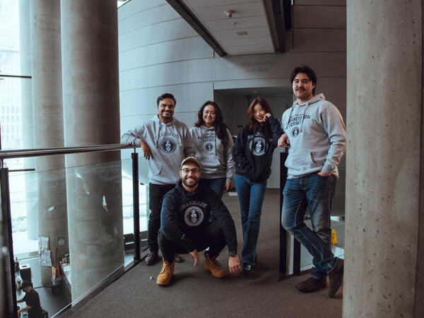 Leslie Dan Faculty of Pharmacy students posing in faculty sweaters outside of classroom