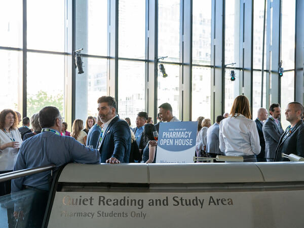 A group of guests in conversation standing on top of third floor lecture pod at the Leslie Dan Faculty of Pharmacy