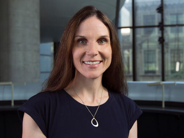 Portrait of Dr. Sara Guilcher with interior of pharmacy building in the background