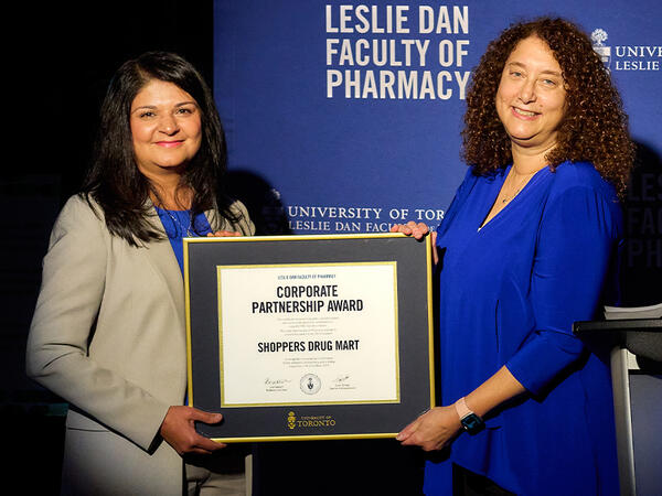 Zebrina Kassam, senior vice president, pharmacy planning and healthcare businesses accepts the 2023 Corporate Partnership Award present by Lisa Dolovich, professor and dean, Leslie Dan Faculty of Pharmacy.