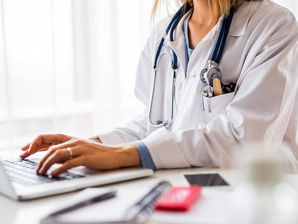 Female doctor with laptop working at the office desk