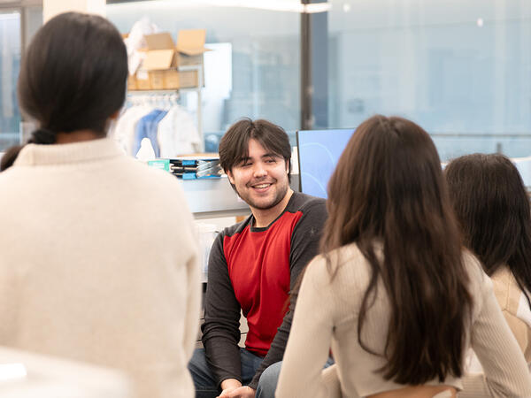 Lab technician Quinn Matthews surrounded by students during protein purification activity