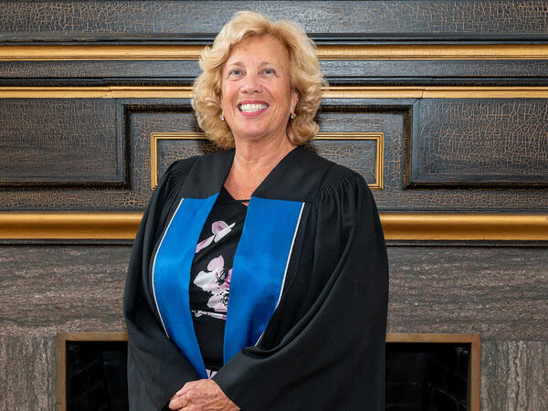 Convocation speaker and U of T Pharmacy alumna Doris Kalamut wearing a black convocation gown with royal blue stole.