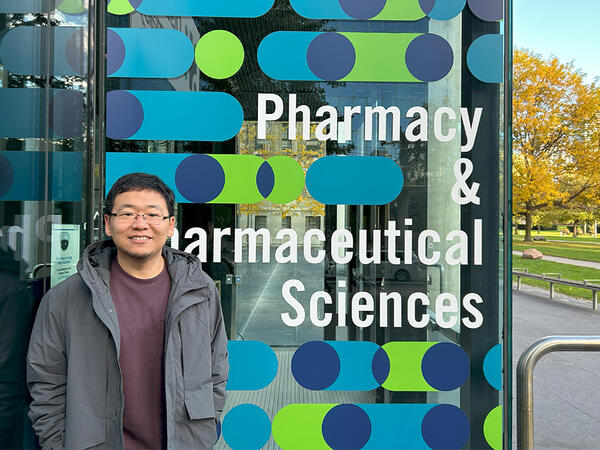 Zeqing Bao in front of Pharmacy building