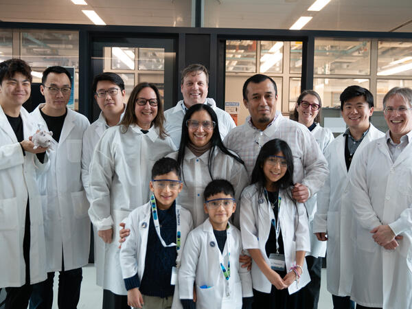 Group of people in lab coats standing infront of lab