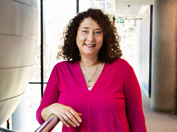 Portrait of Dean Lisa Dolovich standing in Leslie Dan Faculty of Pharmacy building next to second floor lecture pod.