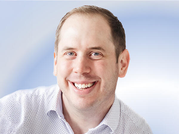 Portrait of Dr. Andrew Sage on blue background Portrait of Dr. Andrew Sage on blue background