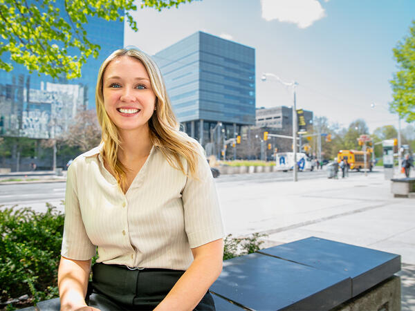 Jenna Sauvé sitting across the street from the Leslie Dan Faculty of Pharmacy building Jenna Sauvé sitting across the street from the Leslie Dan Faculty of Pharmacy building