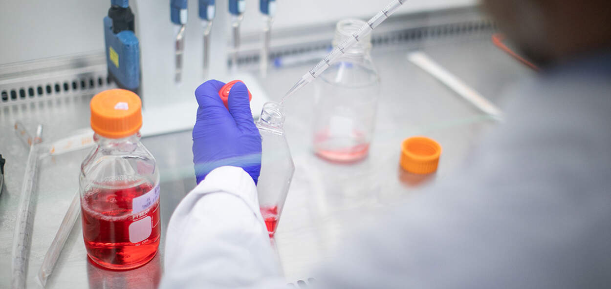 Image of hand pipetting under hood in lab Image of hand pipetting under hood in lab