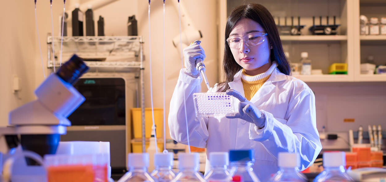 Pharmaceutical Sciences Student pipetting in lab