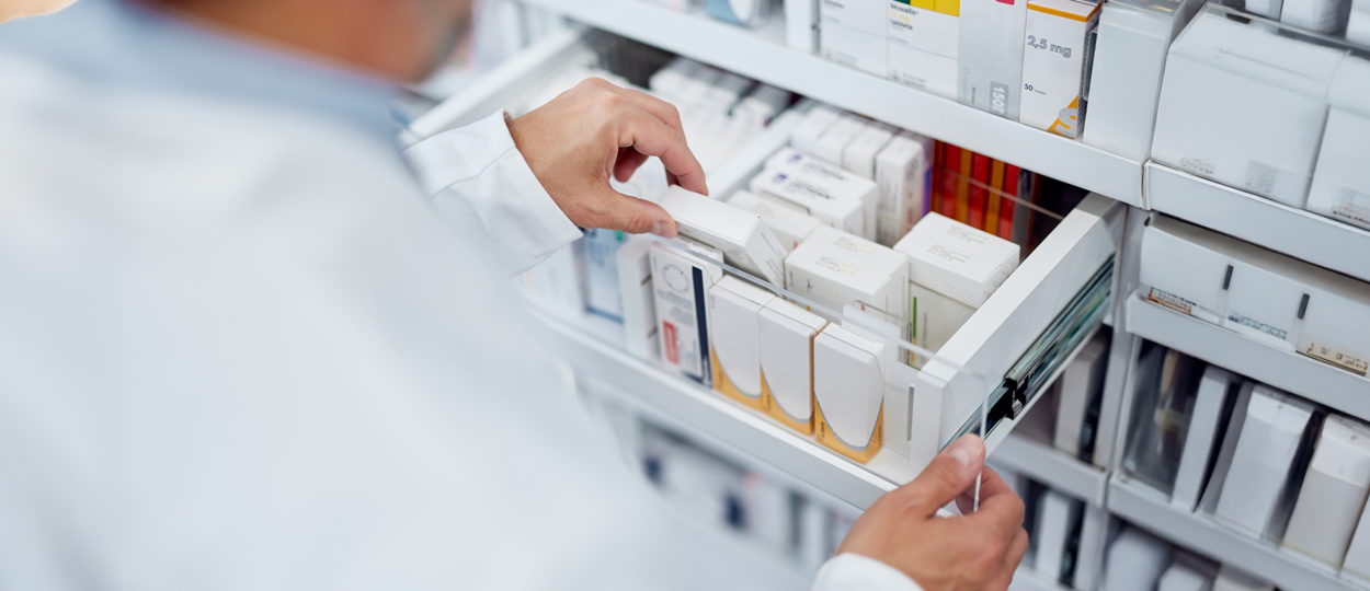 Pharmacist grabbing medication from a drawer in a pharmacy Pharmacist grabbing medication from a drawer in a pharmacy