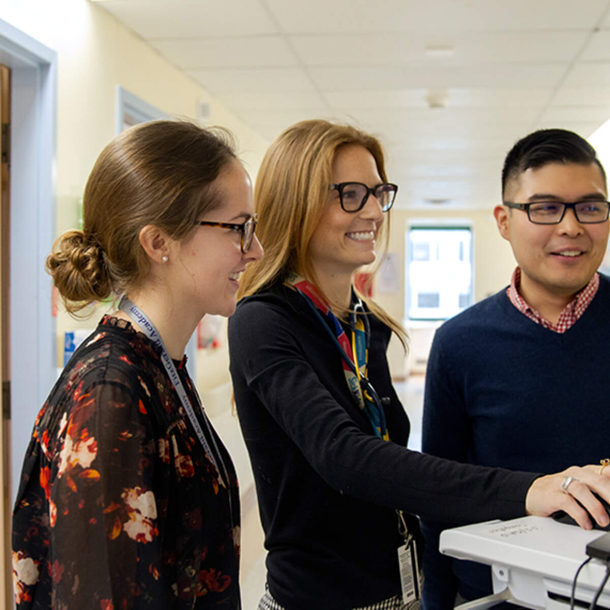 Three pharmacists talking in hospital hallway