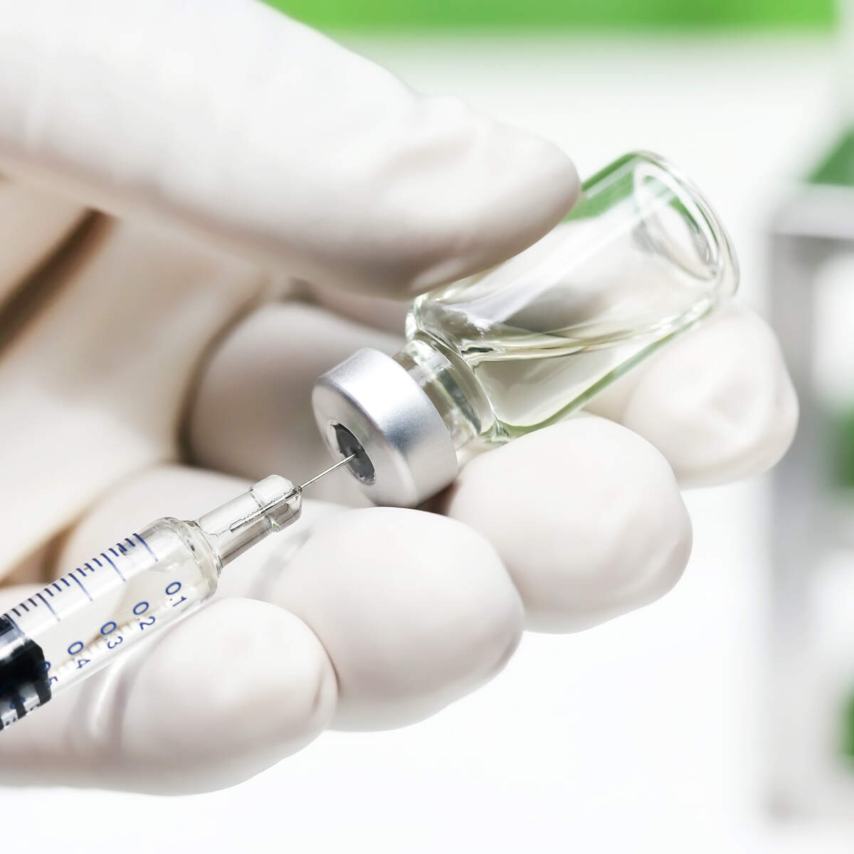 Photo of Needle inserted into vaccine bottle