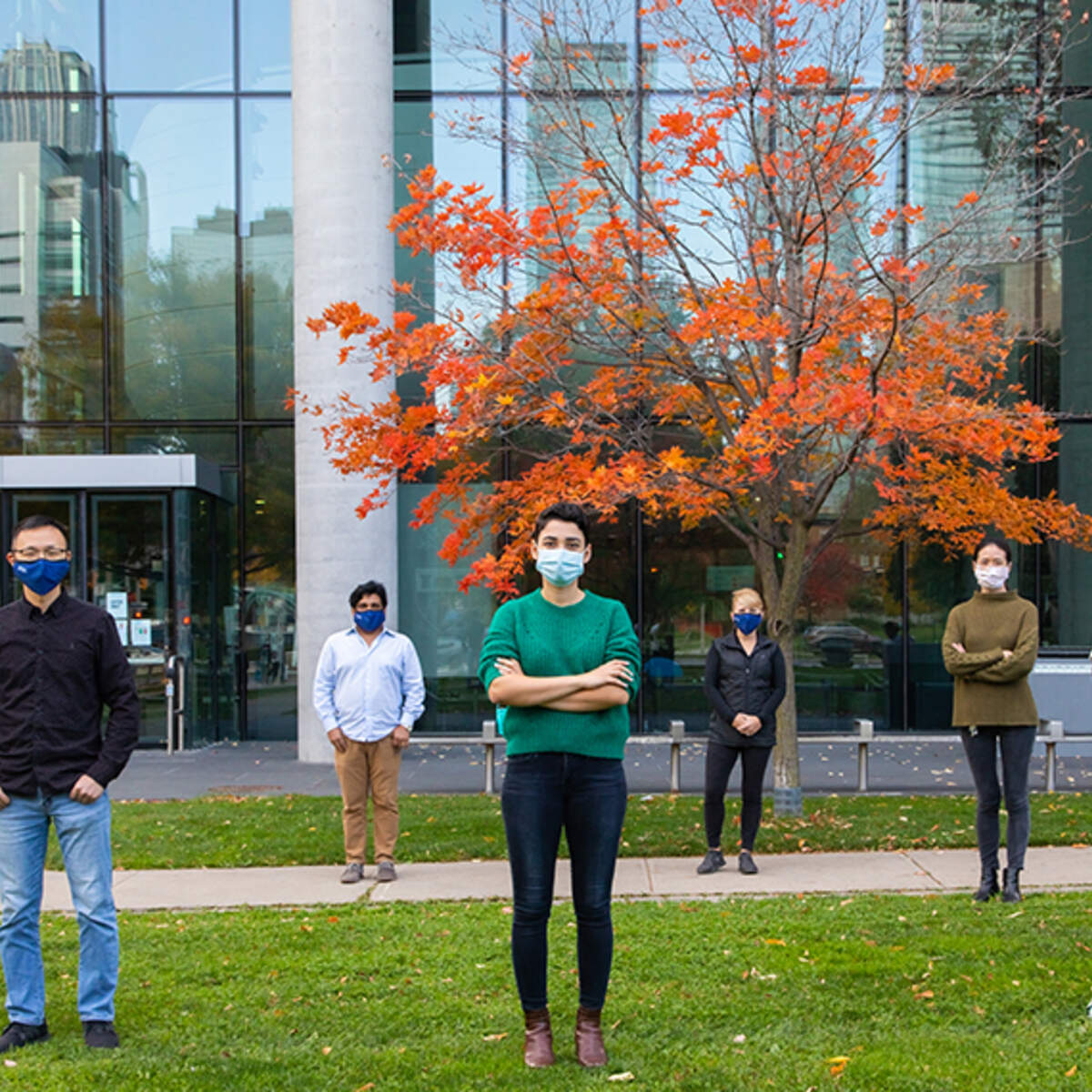 U of T Pharmacy and Engineering Researchers in front of Pharmacy building, physically distanced and wearing masks