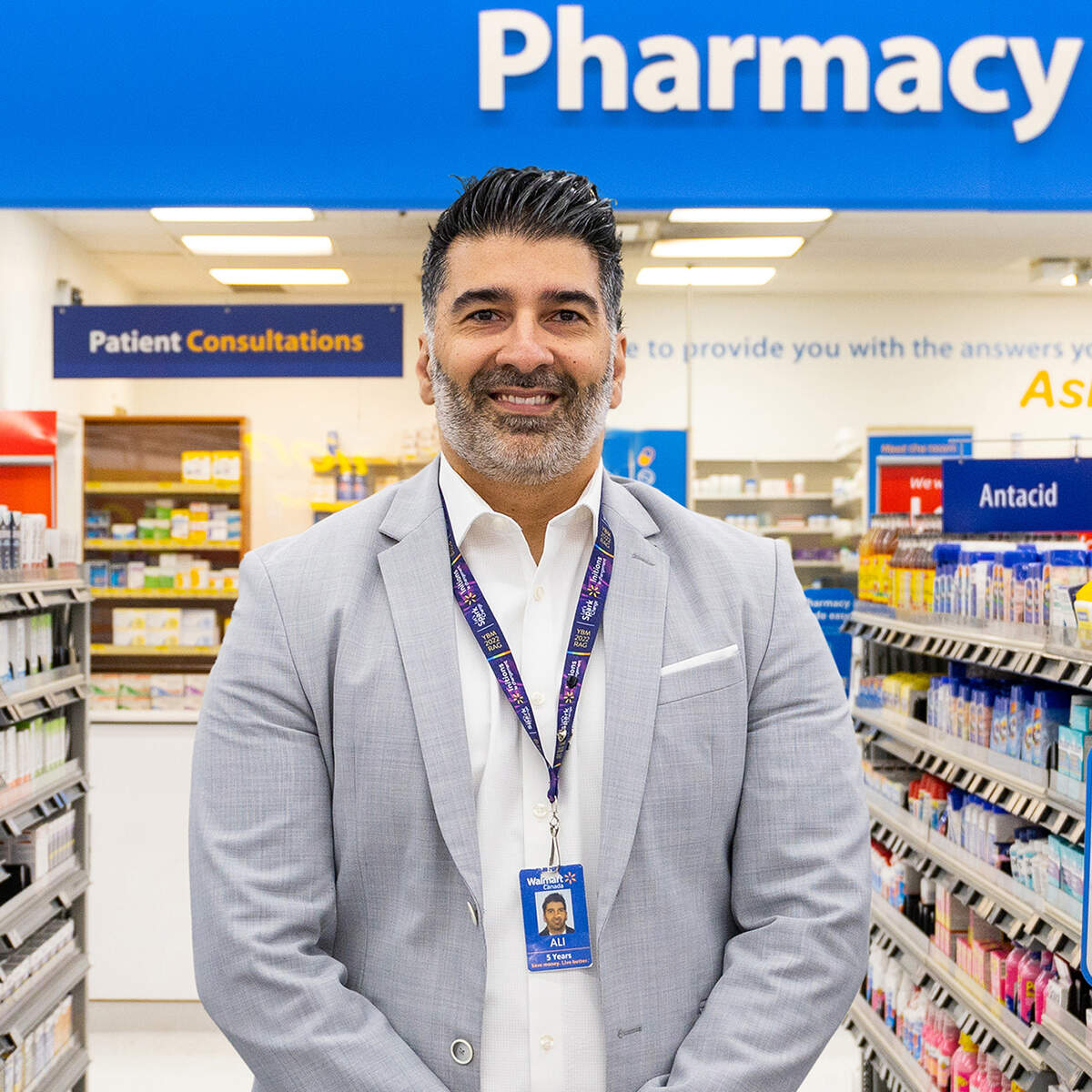 Photo of Ali Ahmadian standing in a Walmart Pharmacy