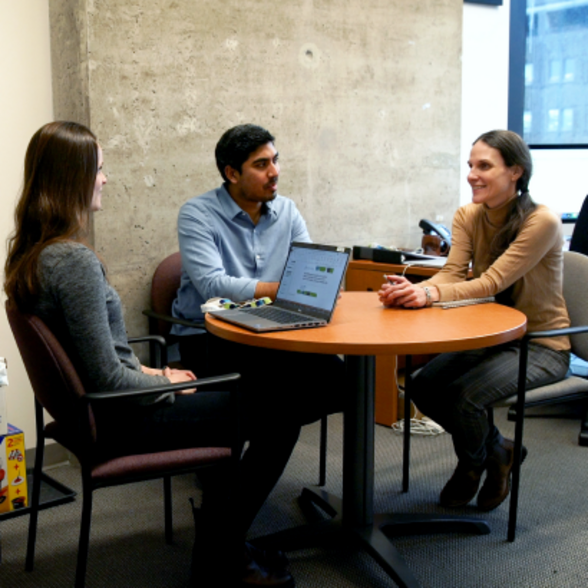 Group of Pharmaceutical Science students conversing at a table.