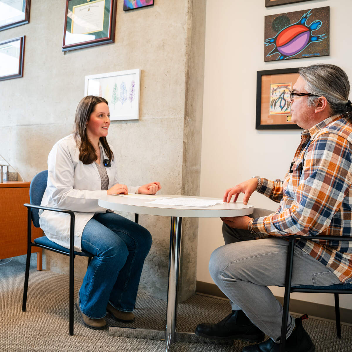 Pharmacy Student and Indigenous patient sitting at table talking
